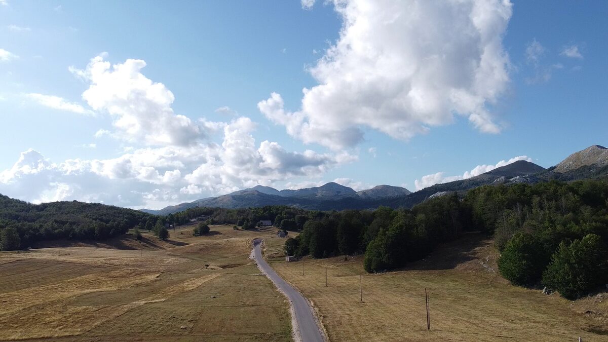 Summer clouds over the plateau, the road and the woods.